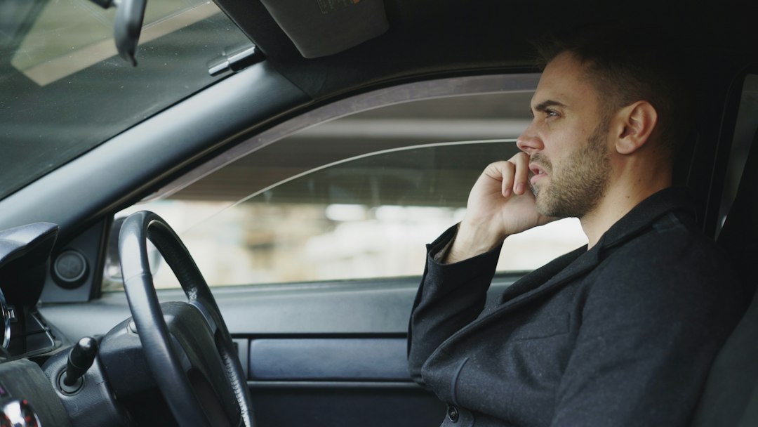 Motorista de terno falando ao celular dentro do carro
