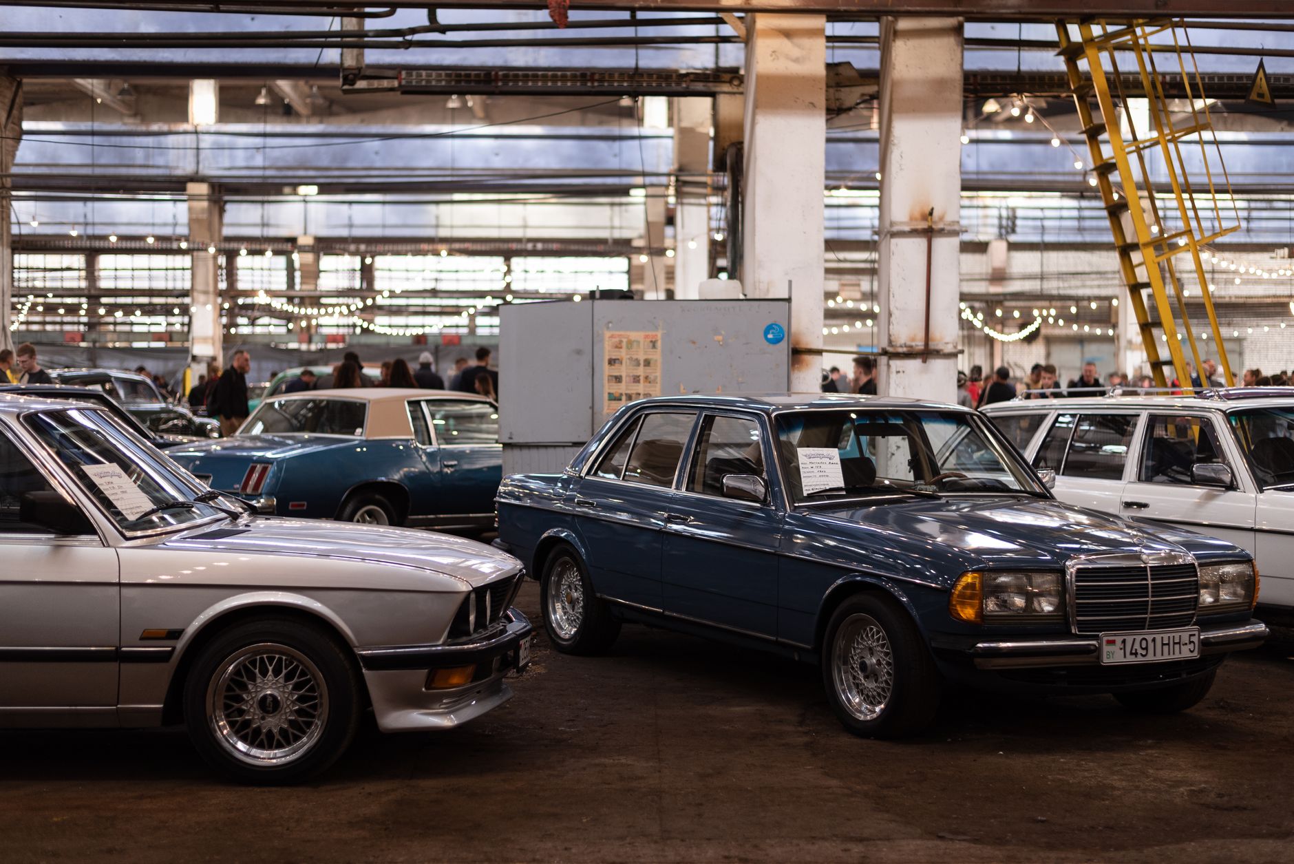 Salão de leilão com carros sedã alinhados para exposição